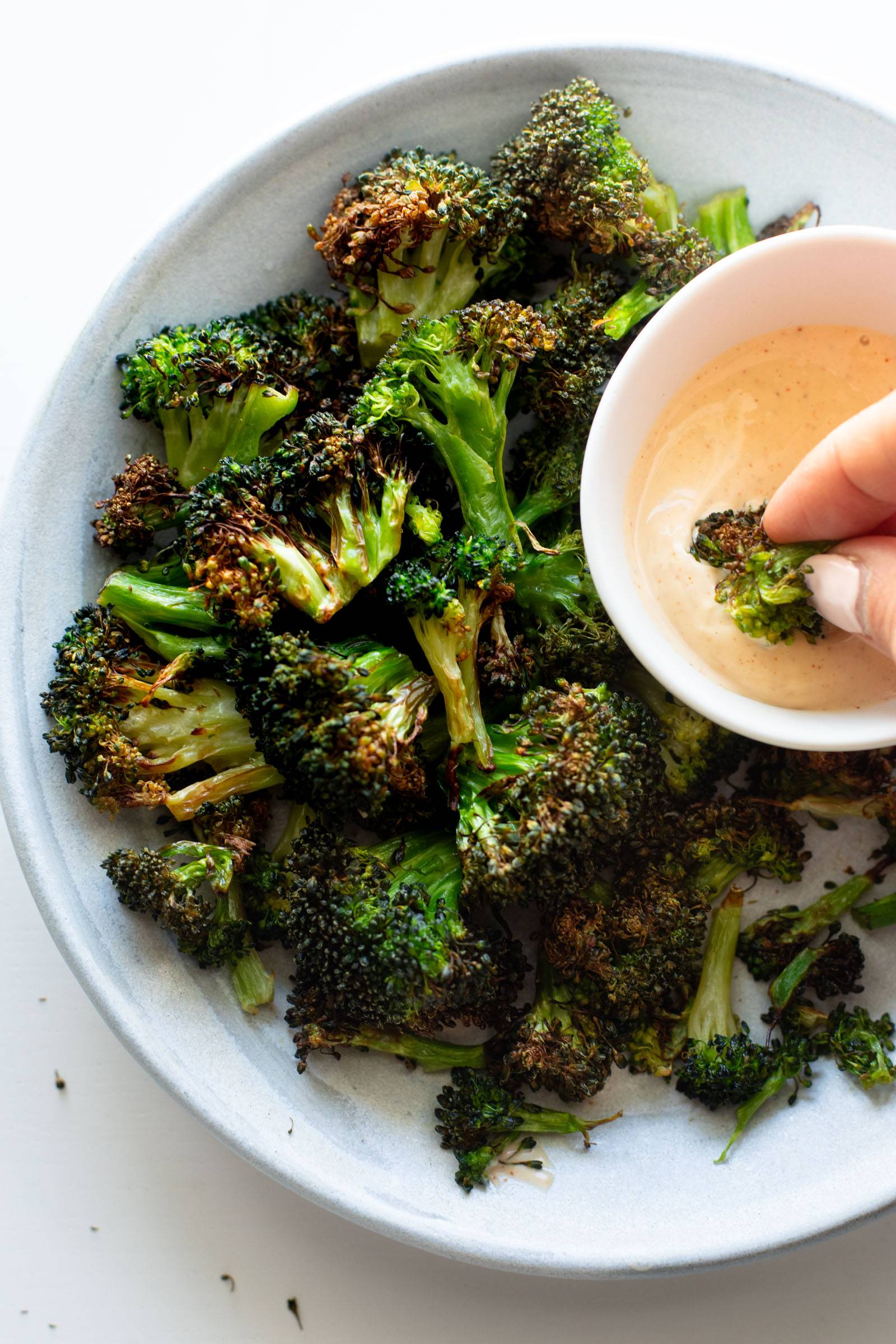 Air Fryer Broccoli on a plate with dipping sauce.