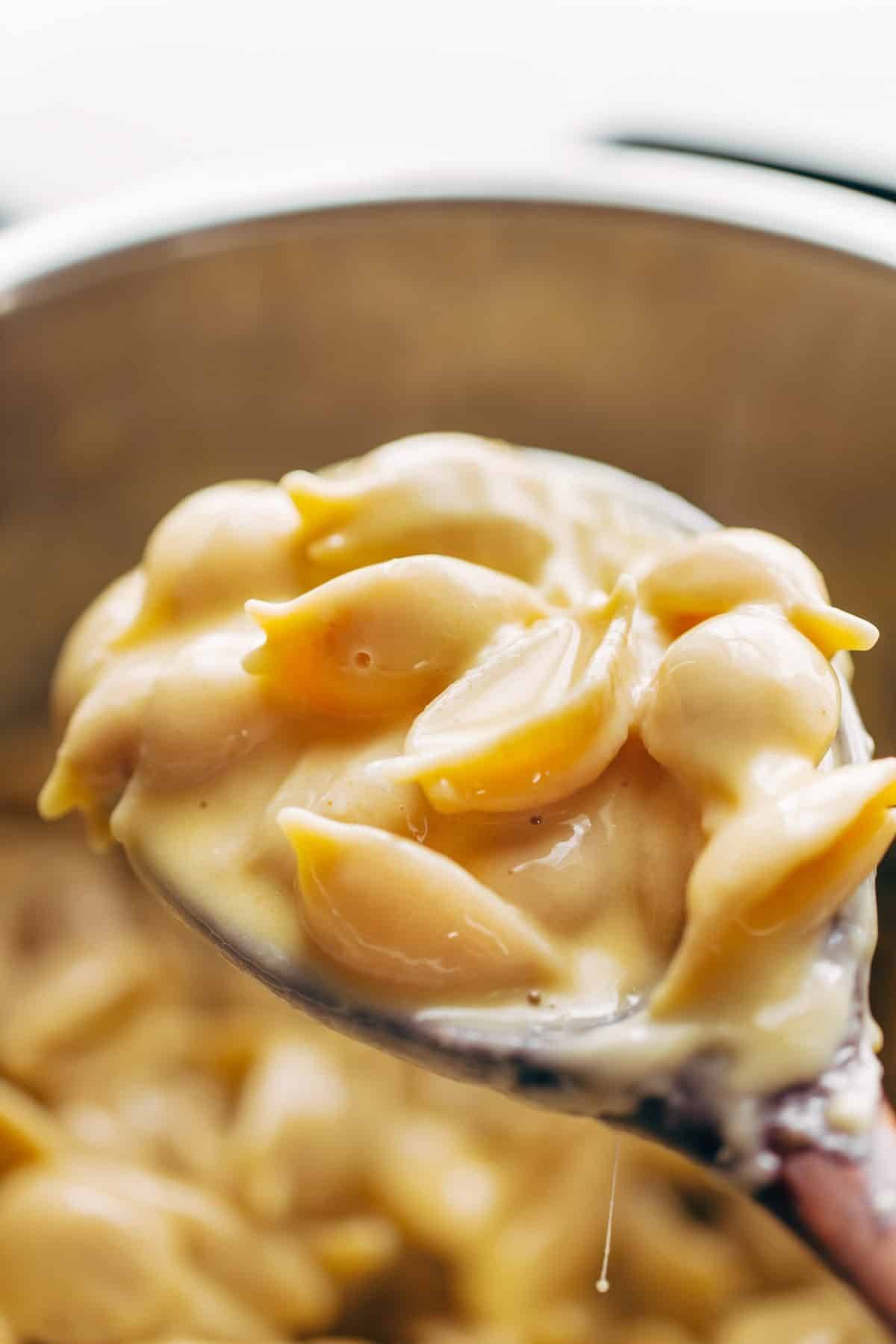 Scooping mac and cheese out of Instant Pot.