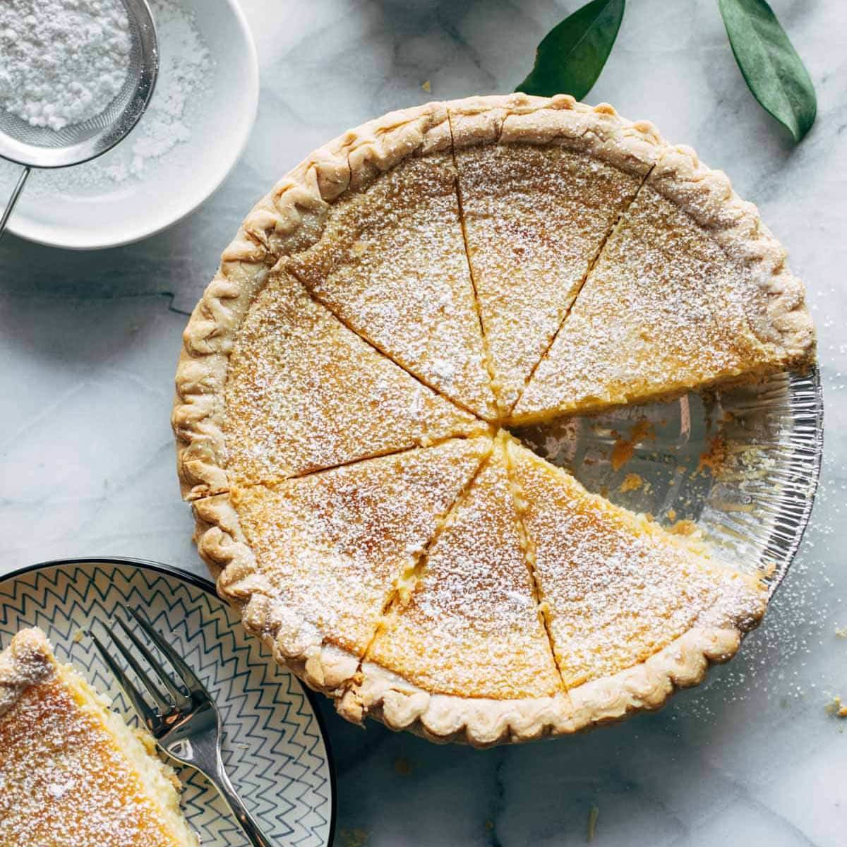 A lemon pie with a slice taken out.