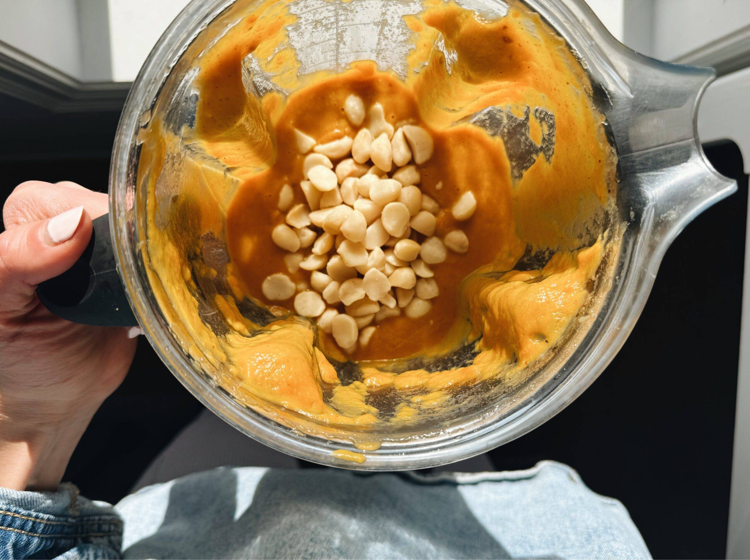 Blending soup in a blender with macadamia nuts.