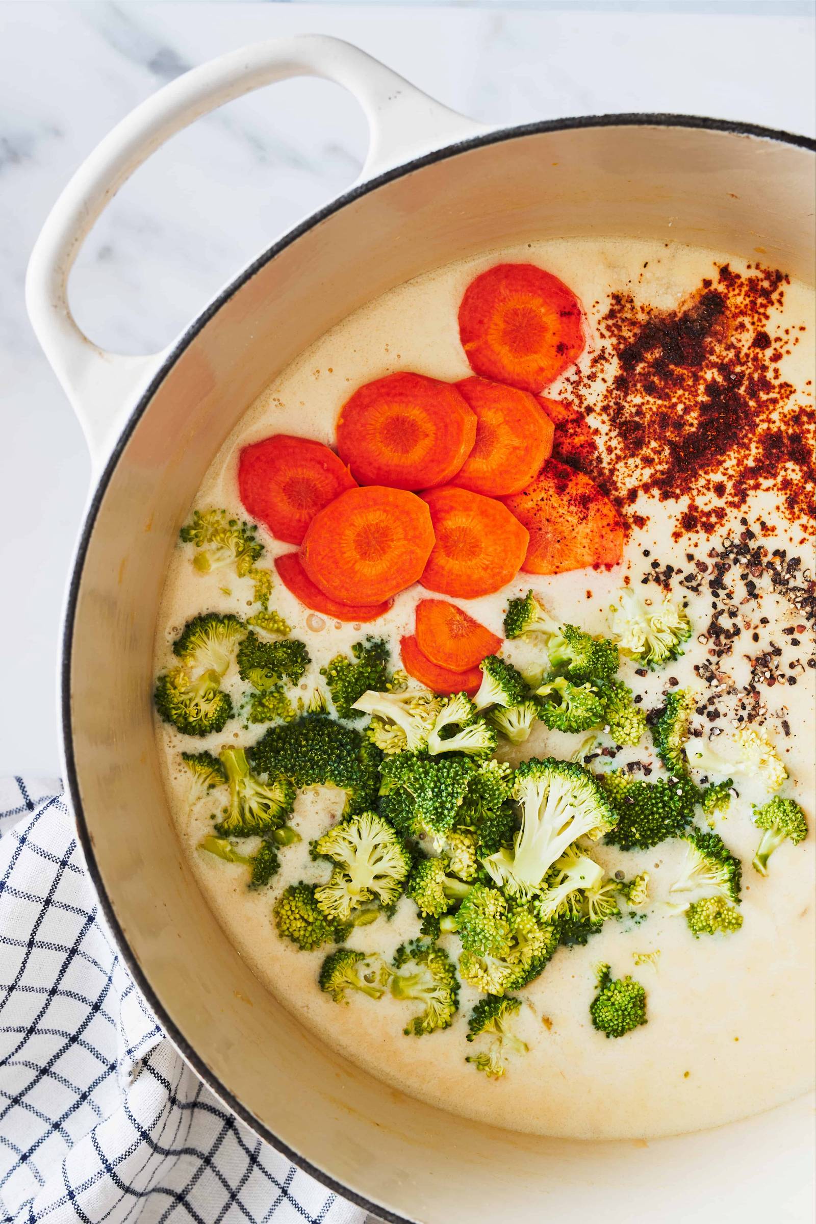 Broccoli cheese soup ingredients in a dutch oven.