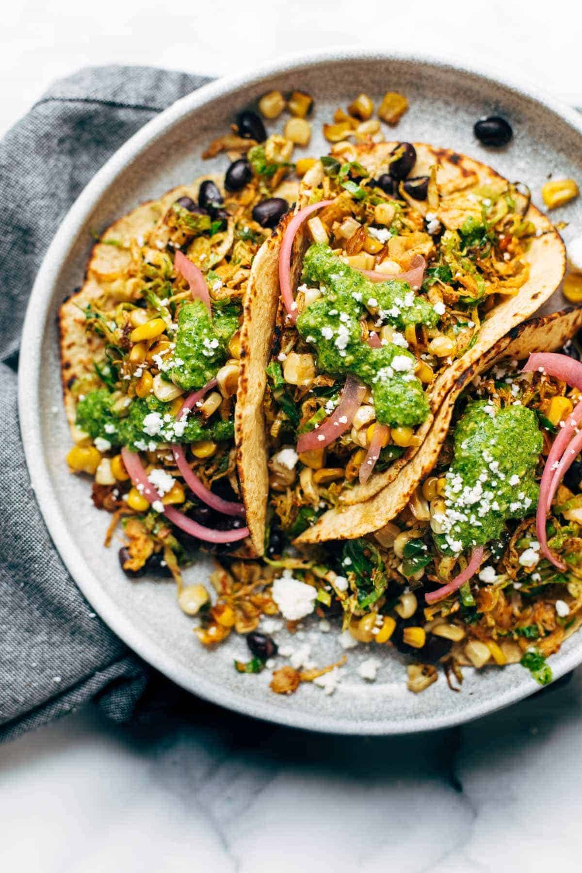 Brussels sprouts tacos on plate with toppings.