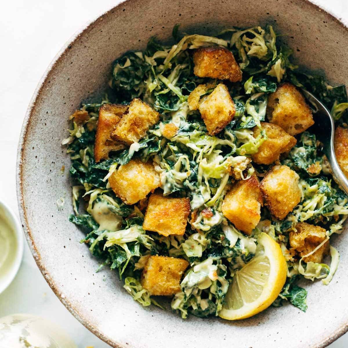 Brussels & Kale Caesar with Cheezy Garlic Croutons via Pinch of Yum