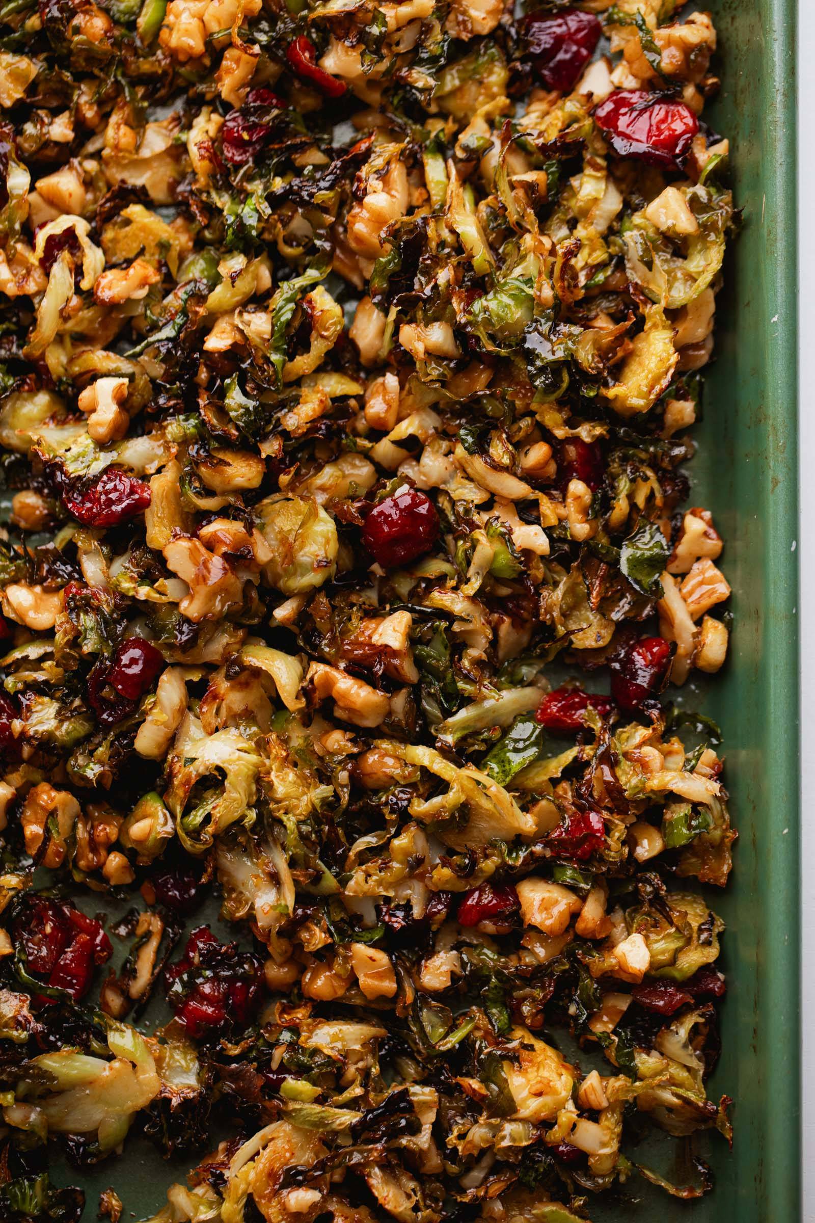 Brussels Sprouts roasted on a sheet pan tossed with Gochujang Butter and walnuts and cranberries