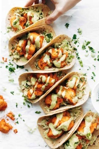 Buffalo Cauliflower Tacos on table in a row.