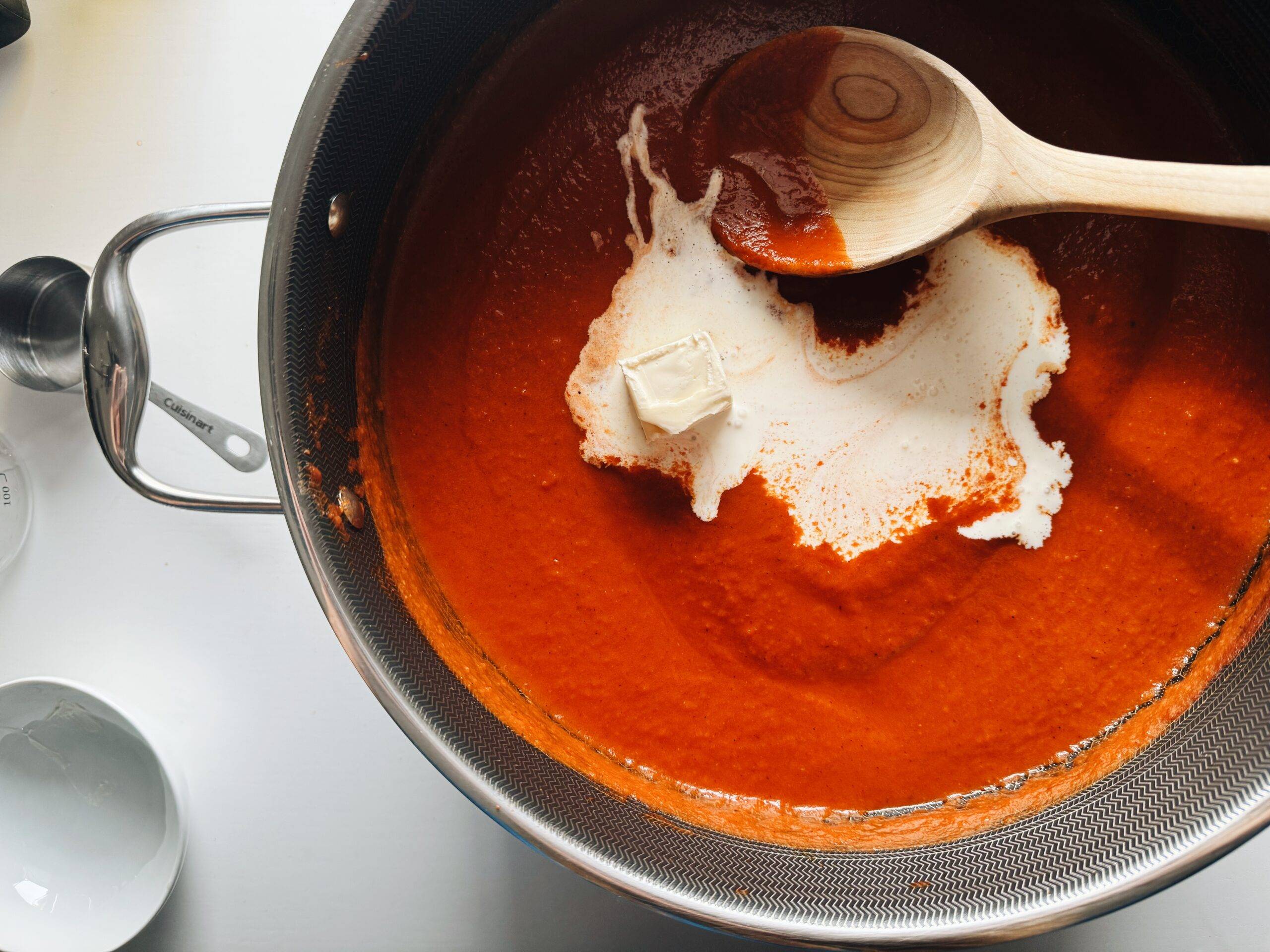 Butter and cream in a pot with butter chicken sauce.