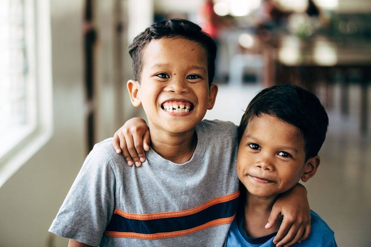 Two young boys smiling at camera.