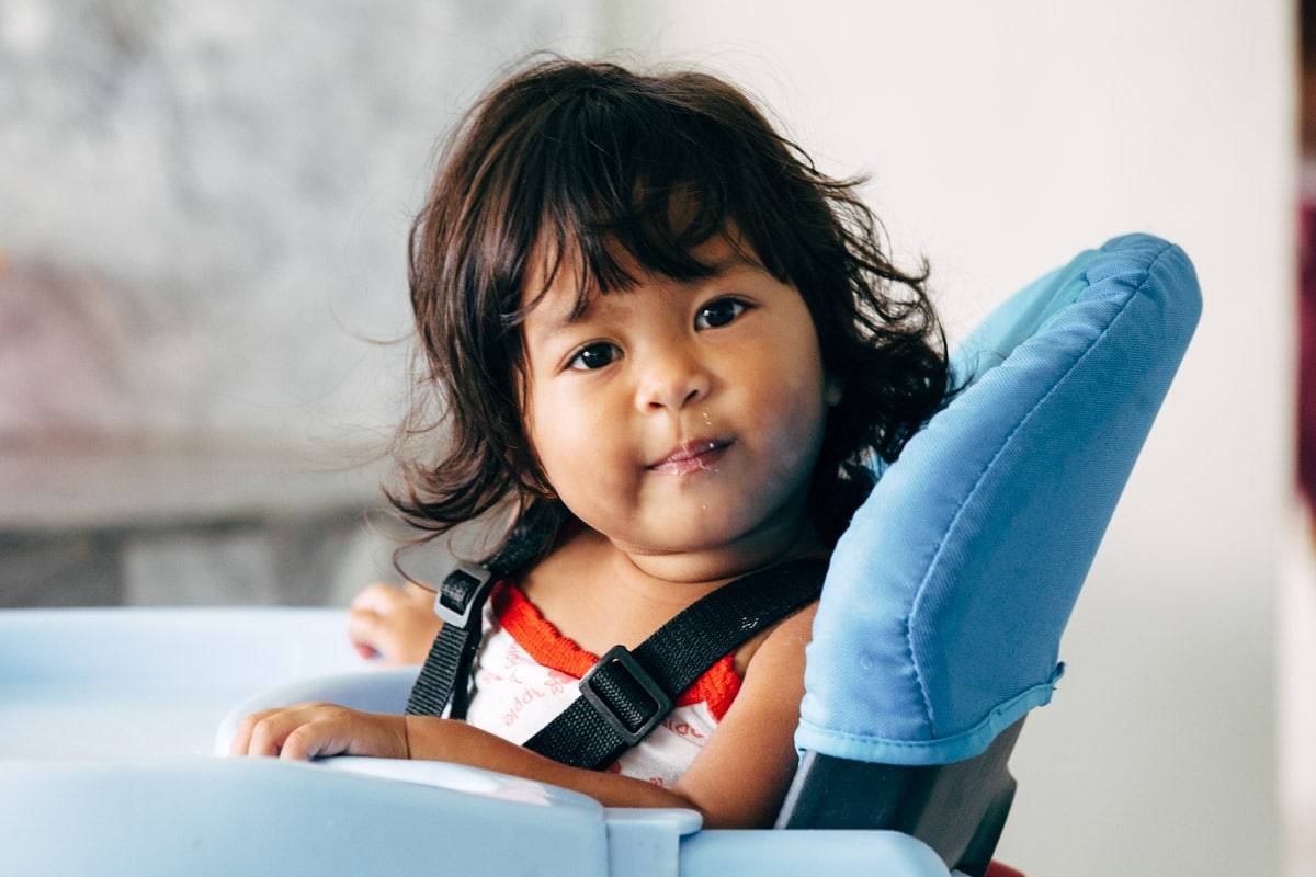 Young girl in a high chair.