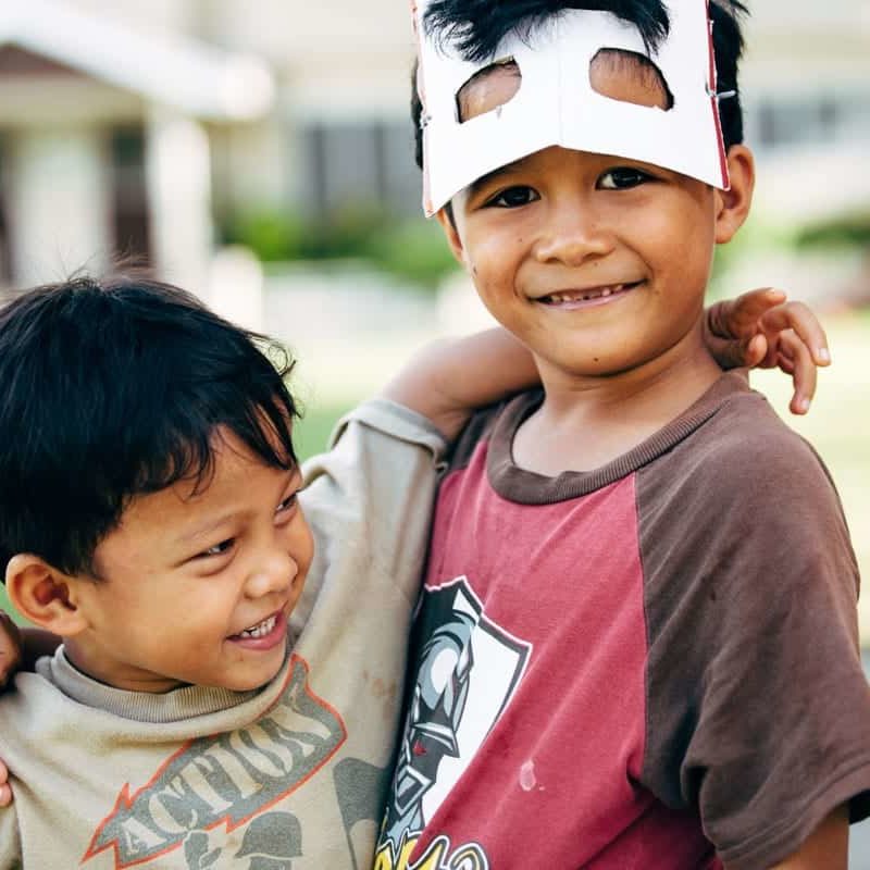 Two young boys playing with masks.