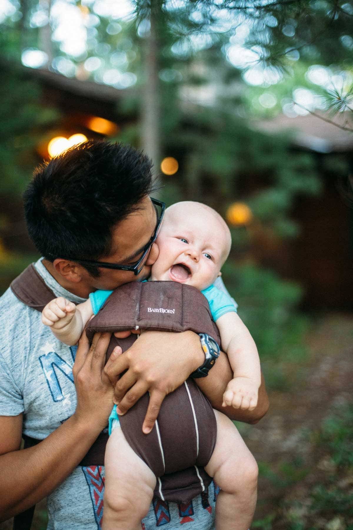 Man kissing baby on the cheek.