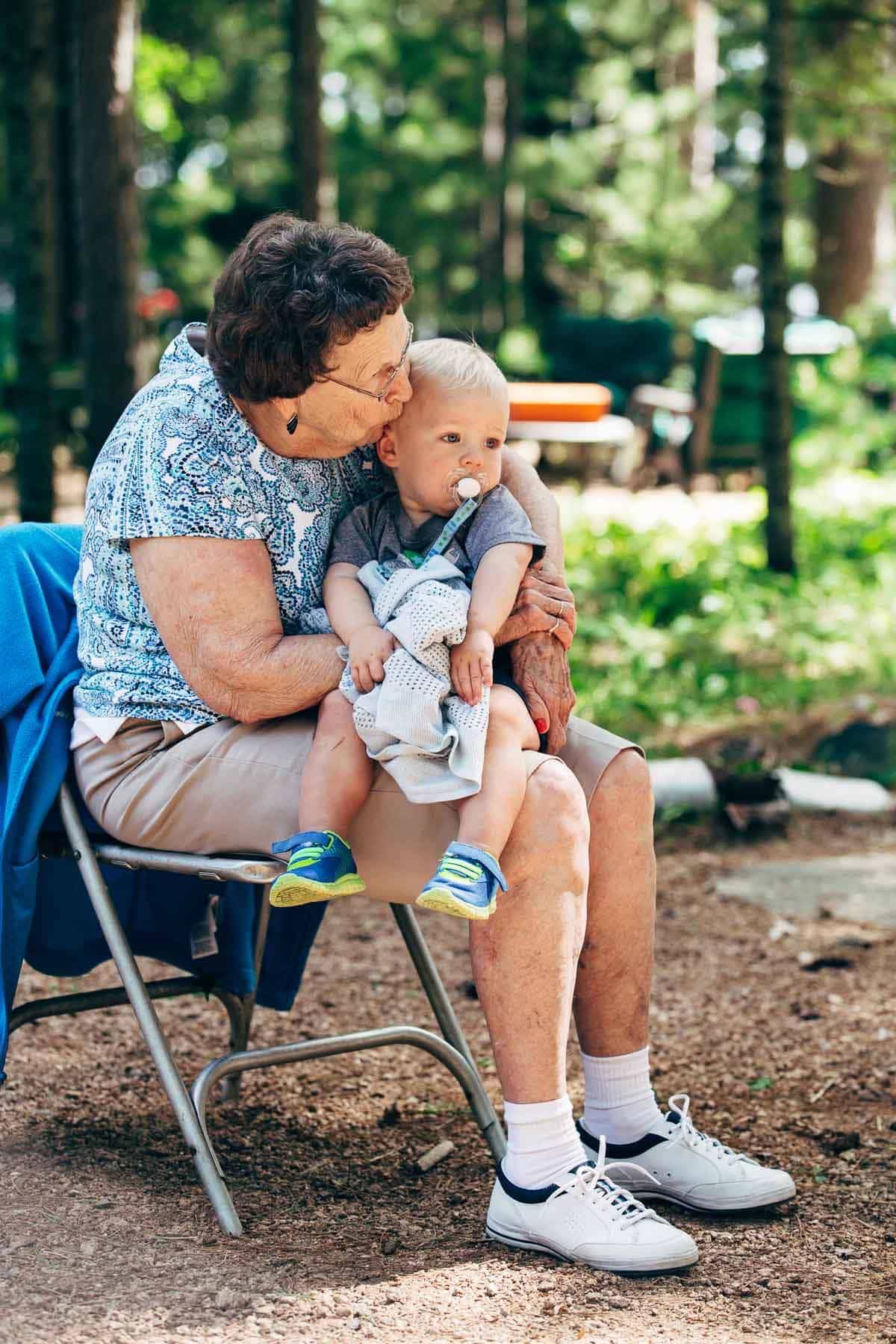 Elderly woman holding a toddler.
