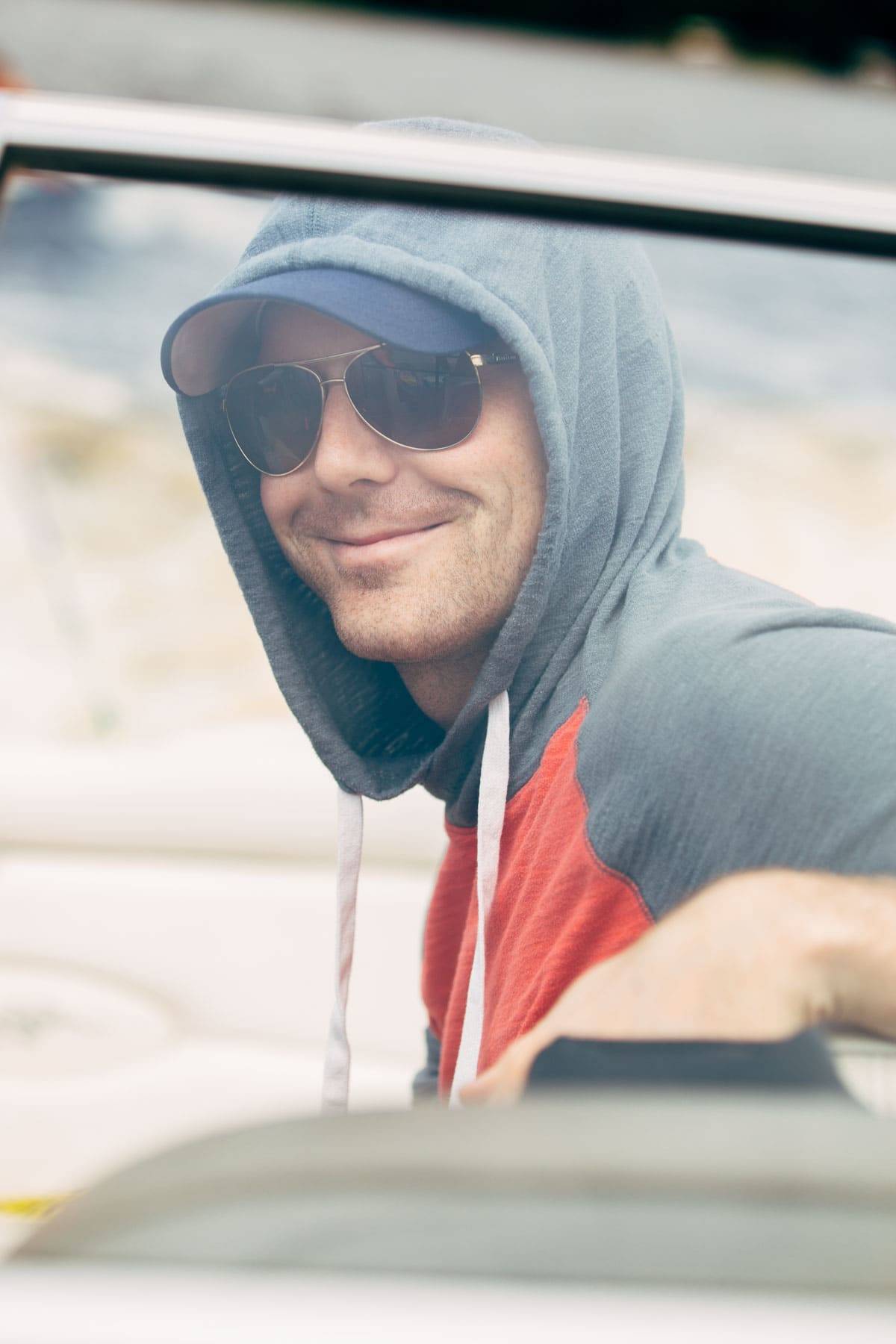 Man wearing a hood and sunglasses.