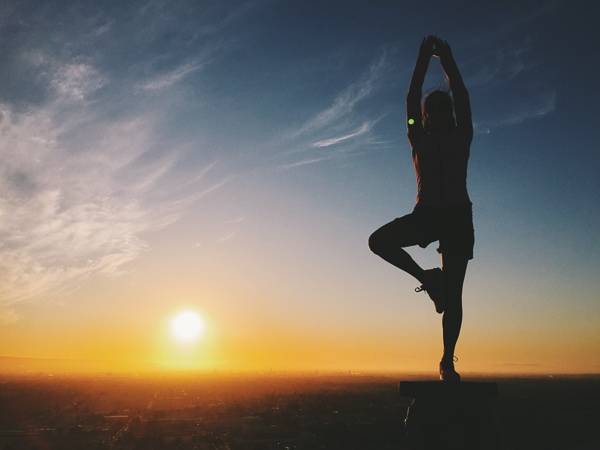 Woman doing a yoga pose in the sunset.