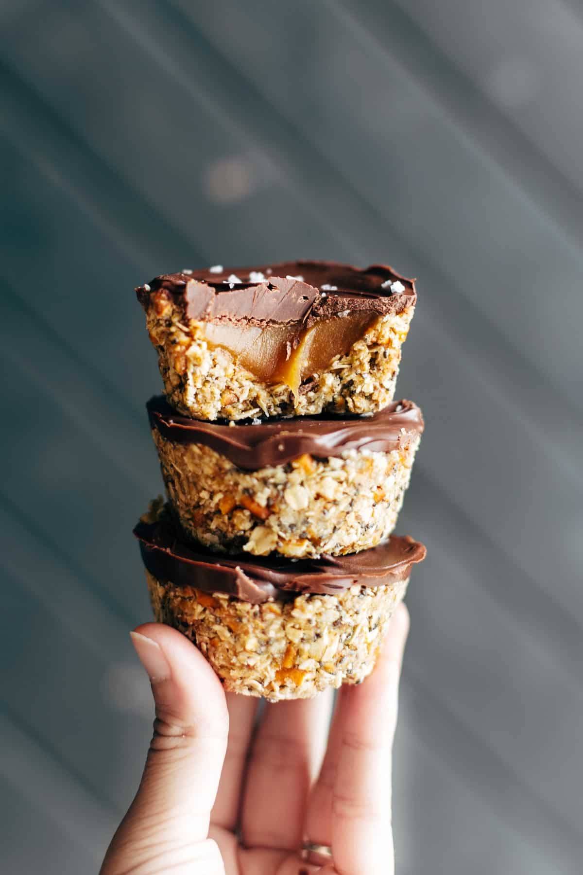 Hand holding three No-Bake Salted Caramel Cups.