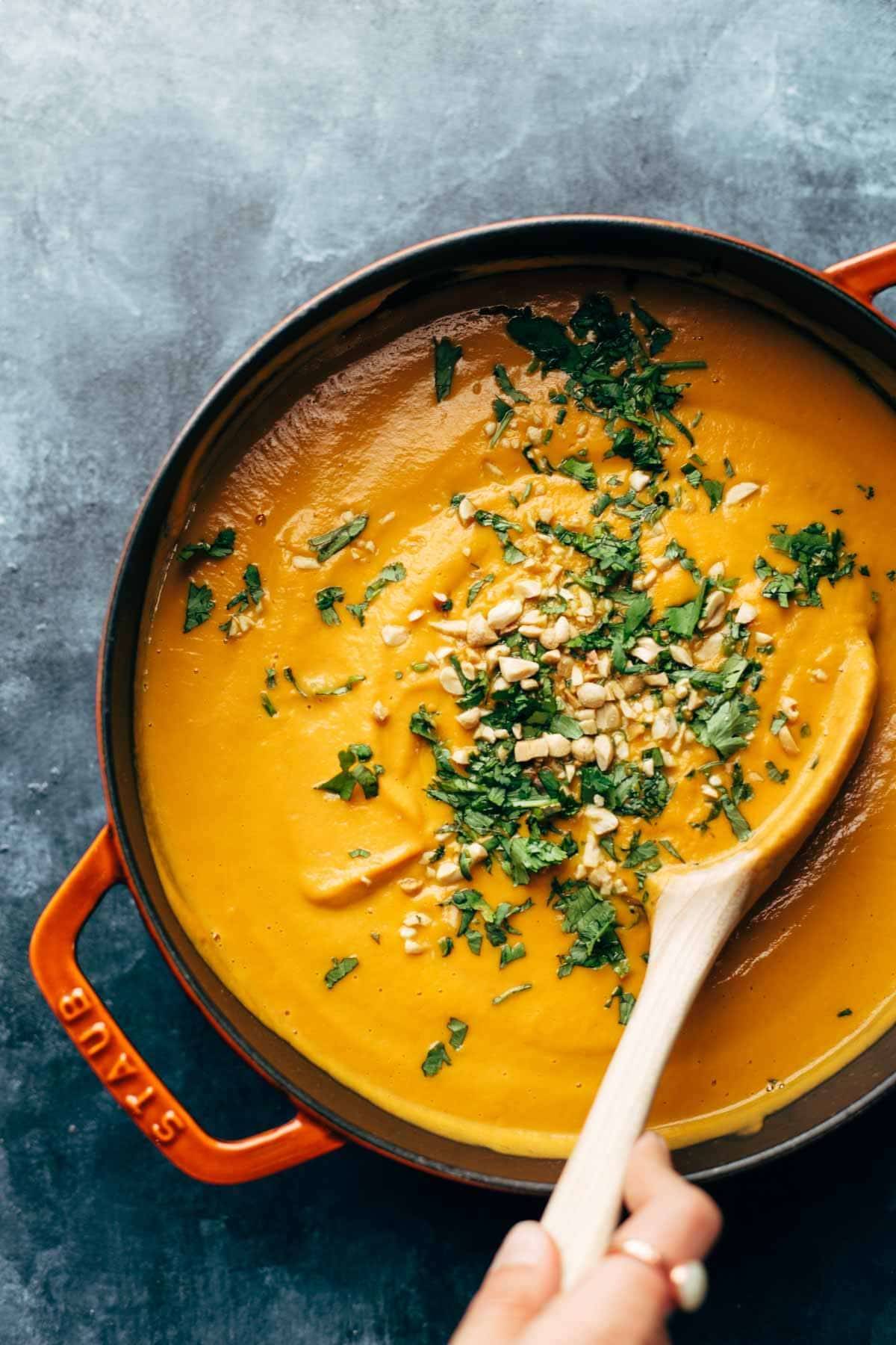 A large pot filled with carrot soup.