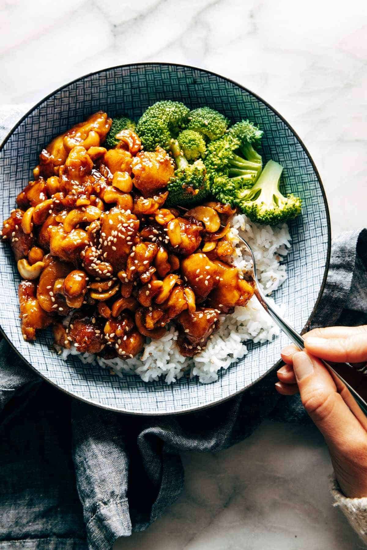 Cashew chicken in a bowl with rice and broccoli.