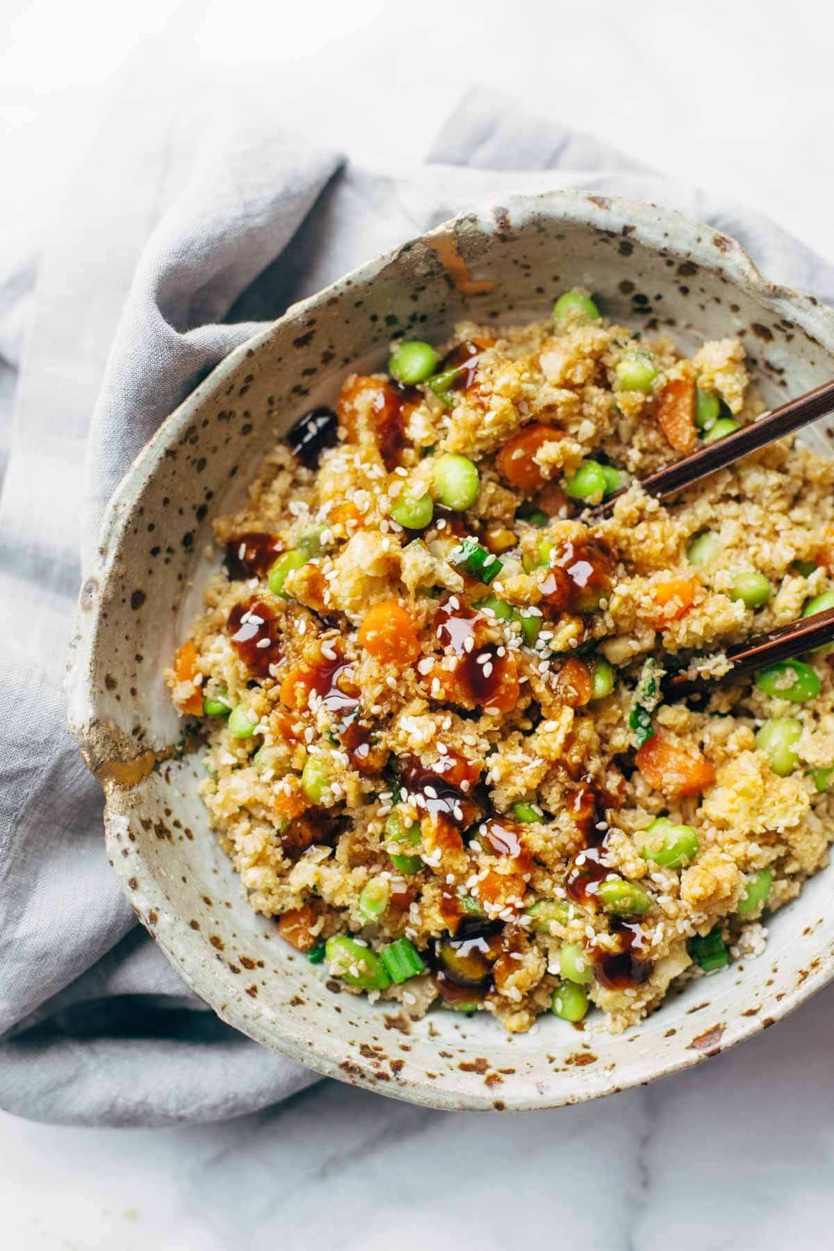 cauliflower fried rice in a bowl on a napkin with chopsticks