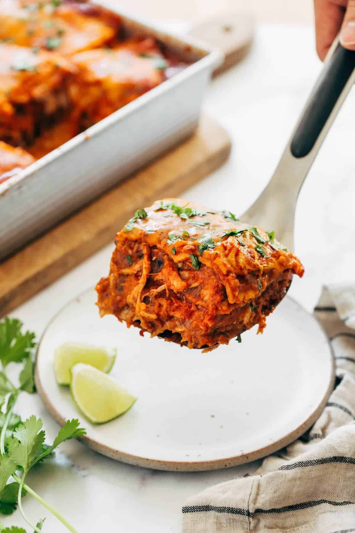 Chicken enchilada casserole on a spatula.