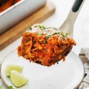 Chicken enchilada casserole being scooped with a spatula