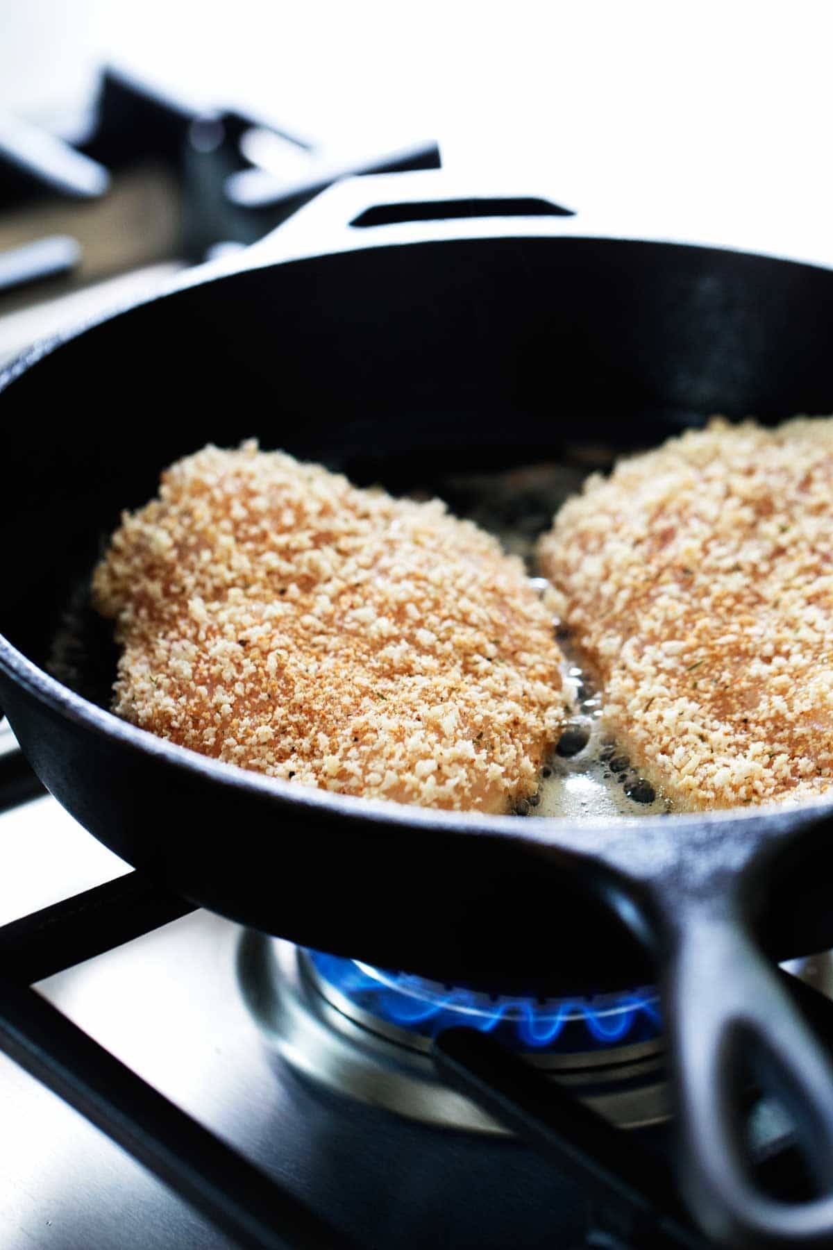 Breaded chicken on a skillet.