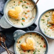 Chicken pot pie soup in bowls with biscuits on top