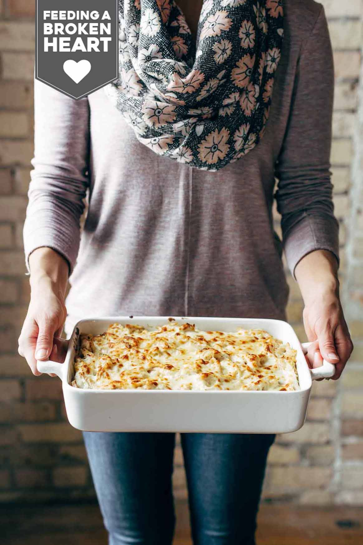 Woman with a scarf holding a pan of Chicken Tetrazzini.