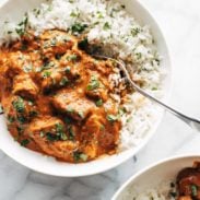 A bowl of chicken tikka masala sauce on a bed of white rice.