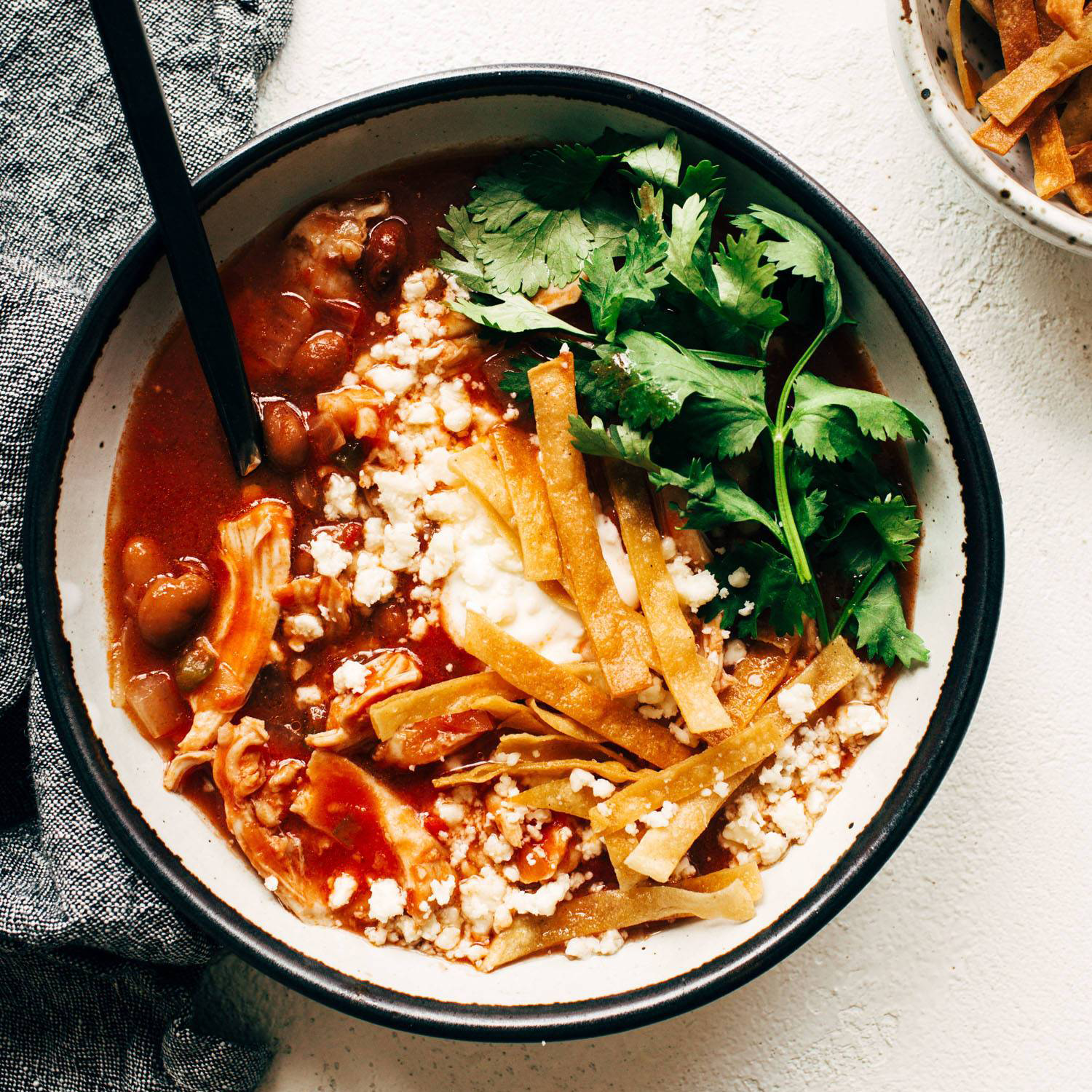 Chicken tortilla soup in a bowl with cilantro on top.
