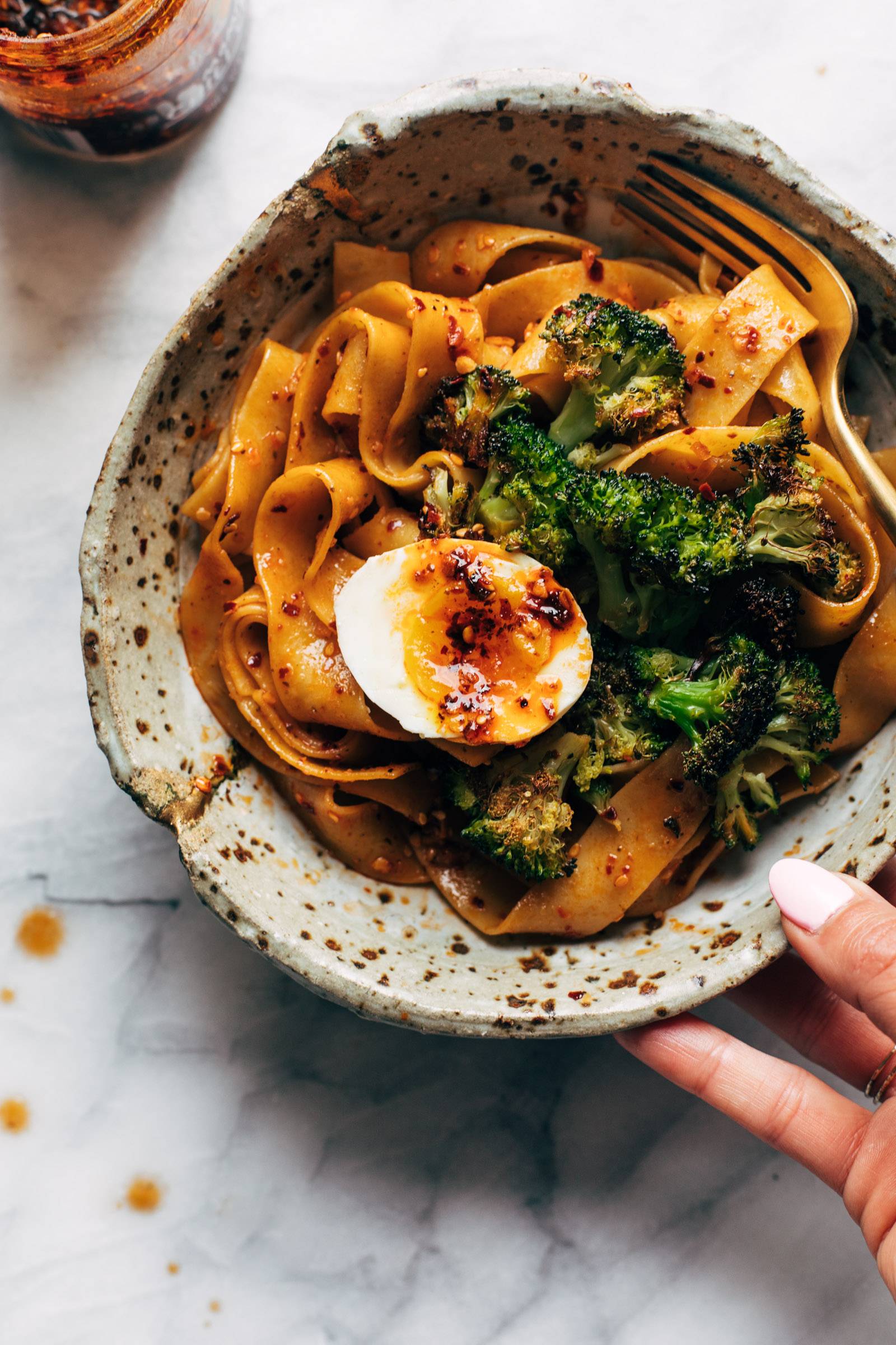 Chili garlic oil noodles with soft boiled egg and broccolini on top