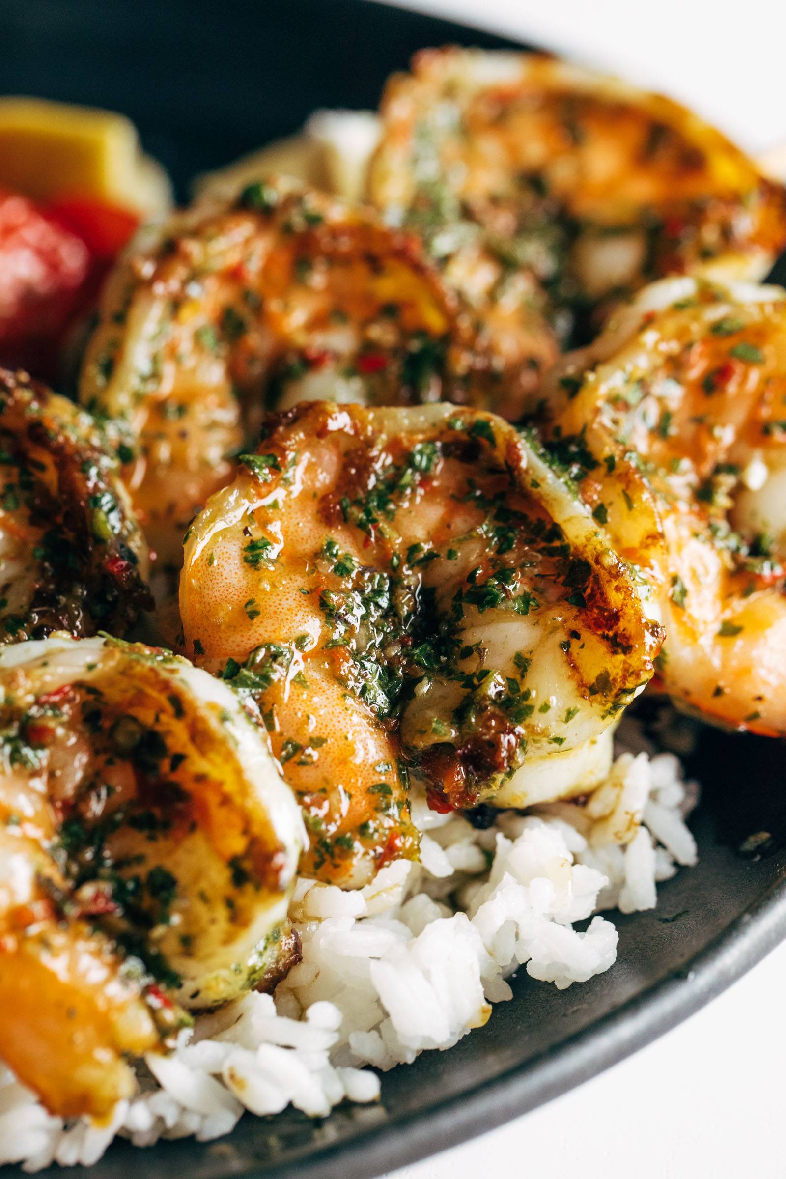 Close-up image of chimichurri shrimp on top of rice.