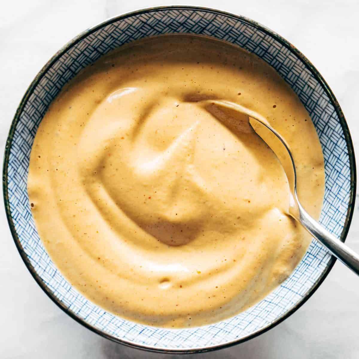 Chipotle cashew queso sauce in a bowl with a spoon.