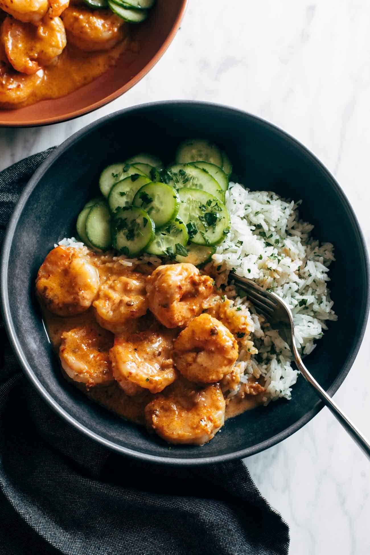 Chipotle orange shrimp in a bowl with rice and cucumbers