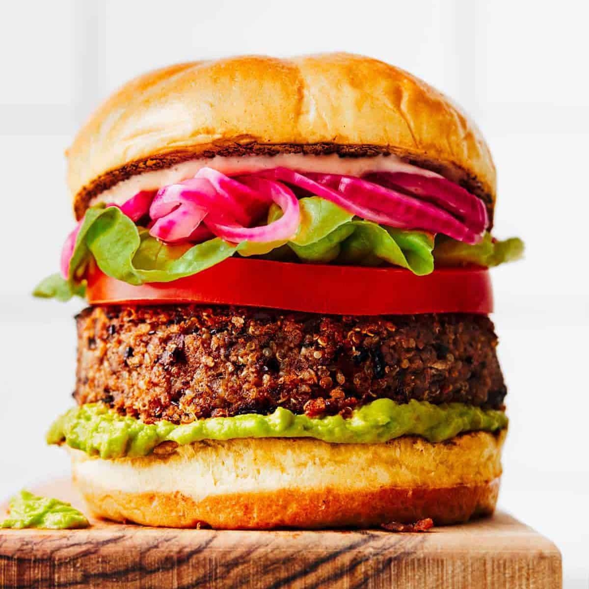 A chipotle quinoa burger with onions, lettuce and tomato.