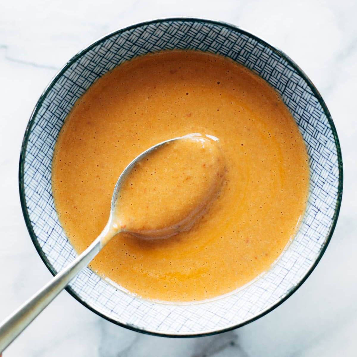 Chipotle tahini sauce in a bowl with a spoon.