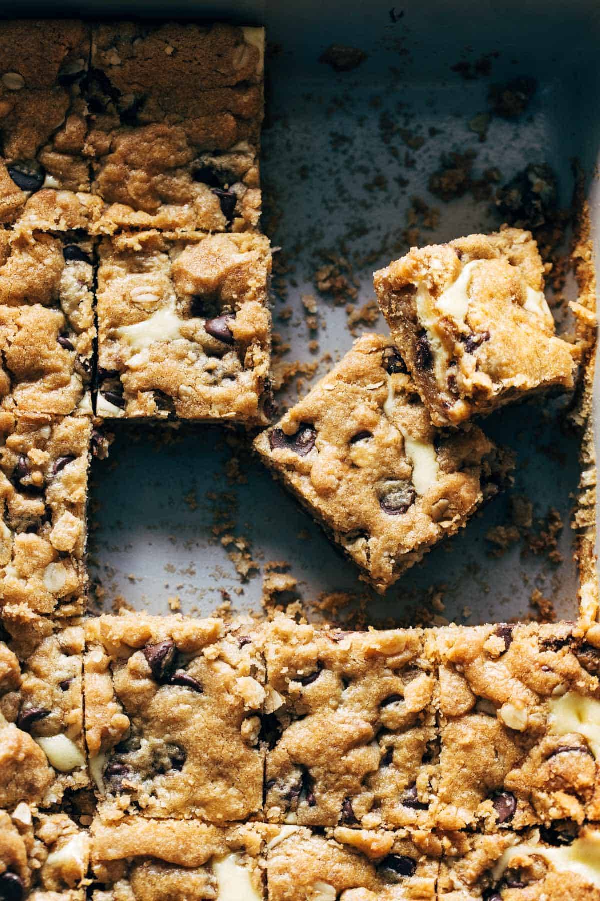 Peanut Butter Chocolate Chip Cookie Cheesecake Bars sliced in a pan.