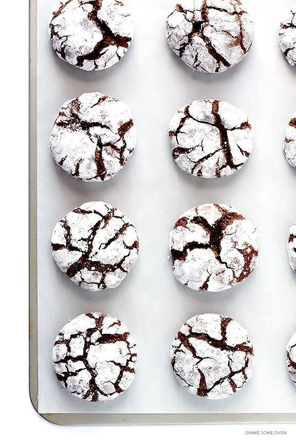 Chocolate crinkle cookies on a sheet pan.