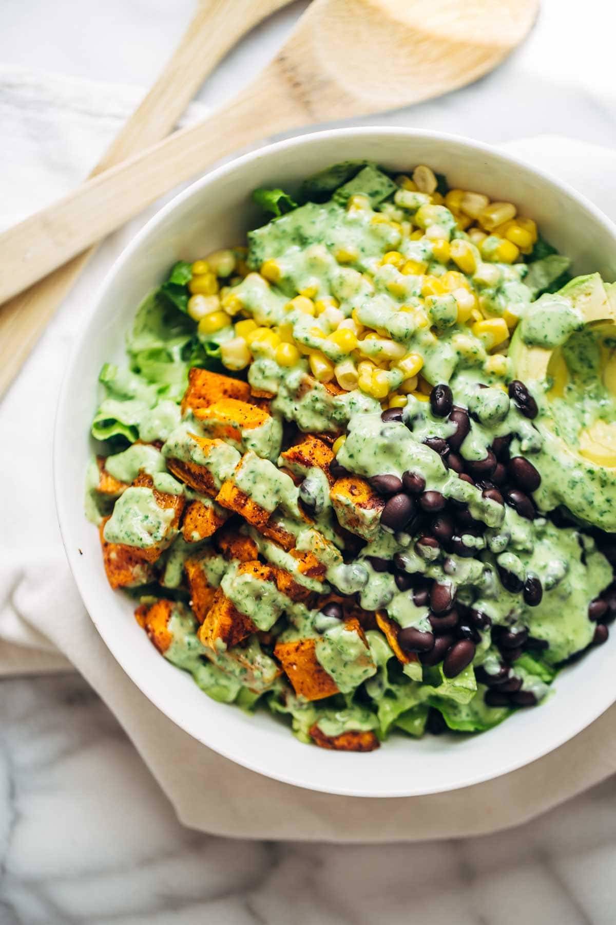 This healthy Spicy Southwestern Salad recipe has roasted sweet potatoes, black beans, corn, lettuce, and creamy avocado dressing! | pinchofyum.com