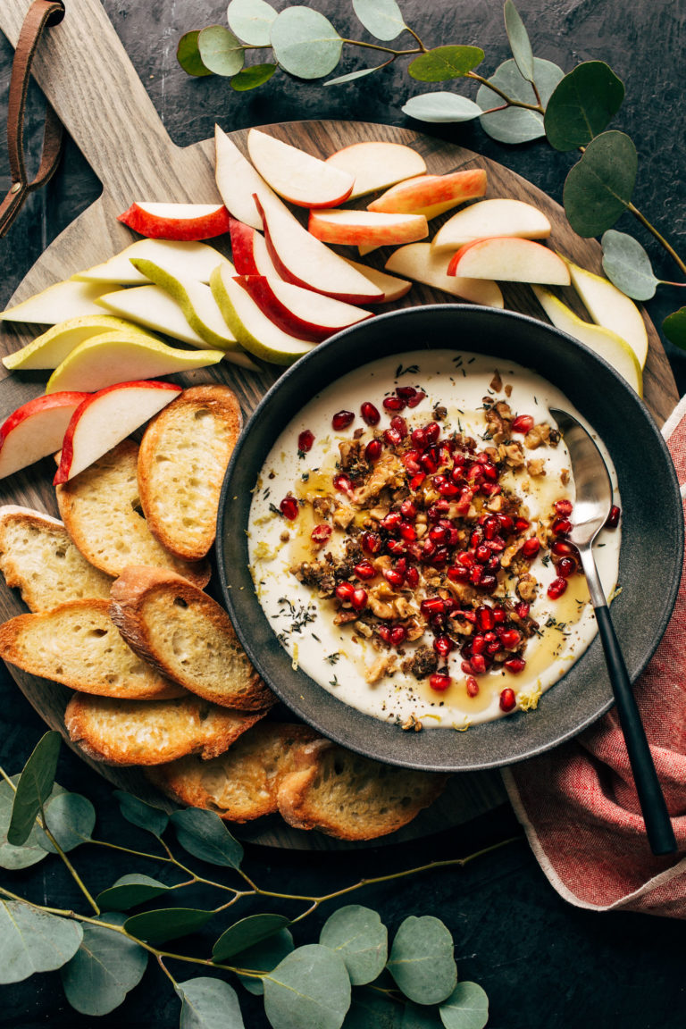 Whipped feta with crackers and fruit on a platter.