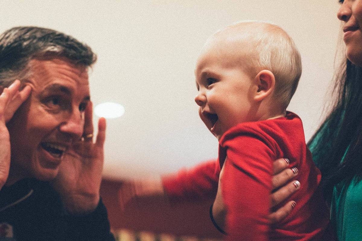 Man making silly faces at a baby.