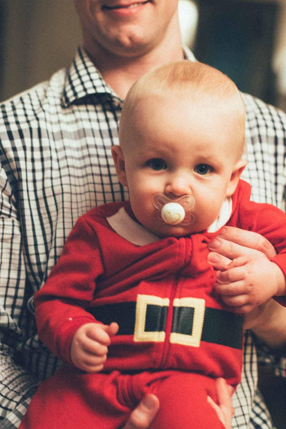 Baby boy wearing a Santa onesie.