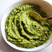 Cilantro pesto in a bowl with a spoon.