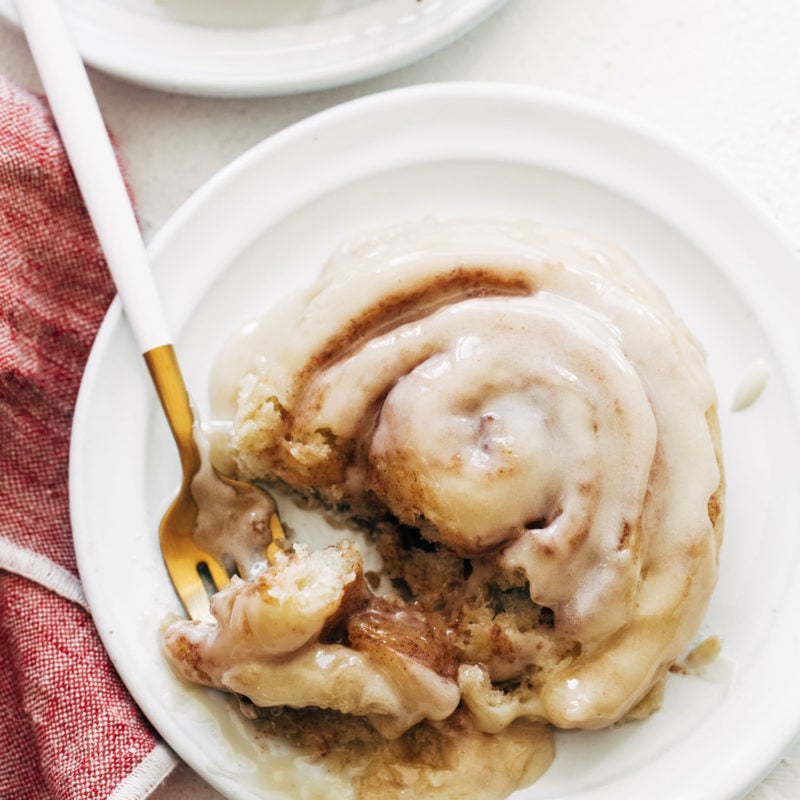 Cinnamon roll on a plate with a fork.