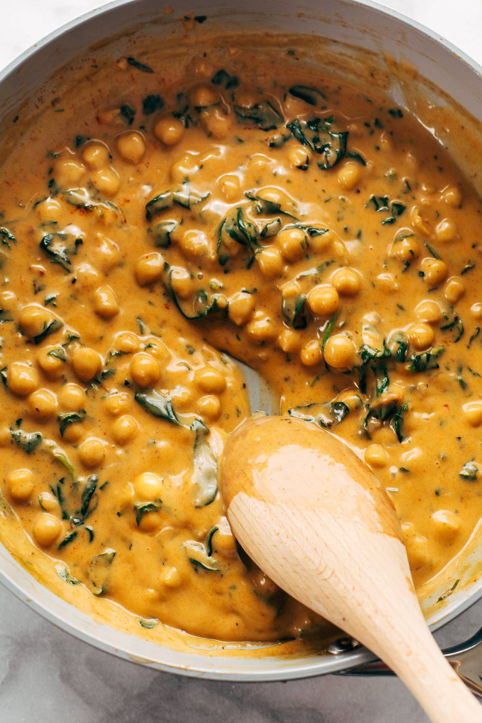 Coconut curry chickpeas with spinach in a pan.