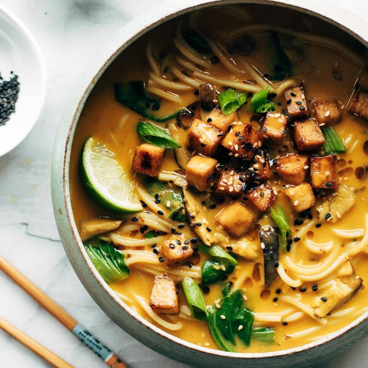 Coconut curry ramen in a bowl next to chopsticks