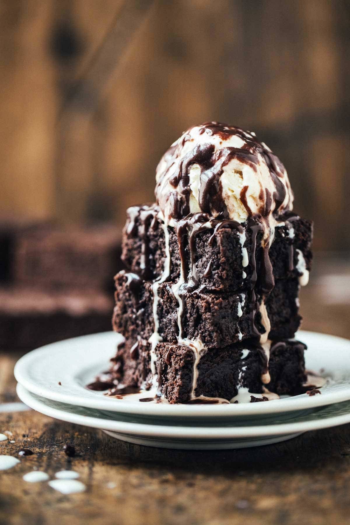 Brownies with chocolate drizzle and ice cream.