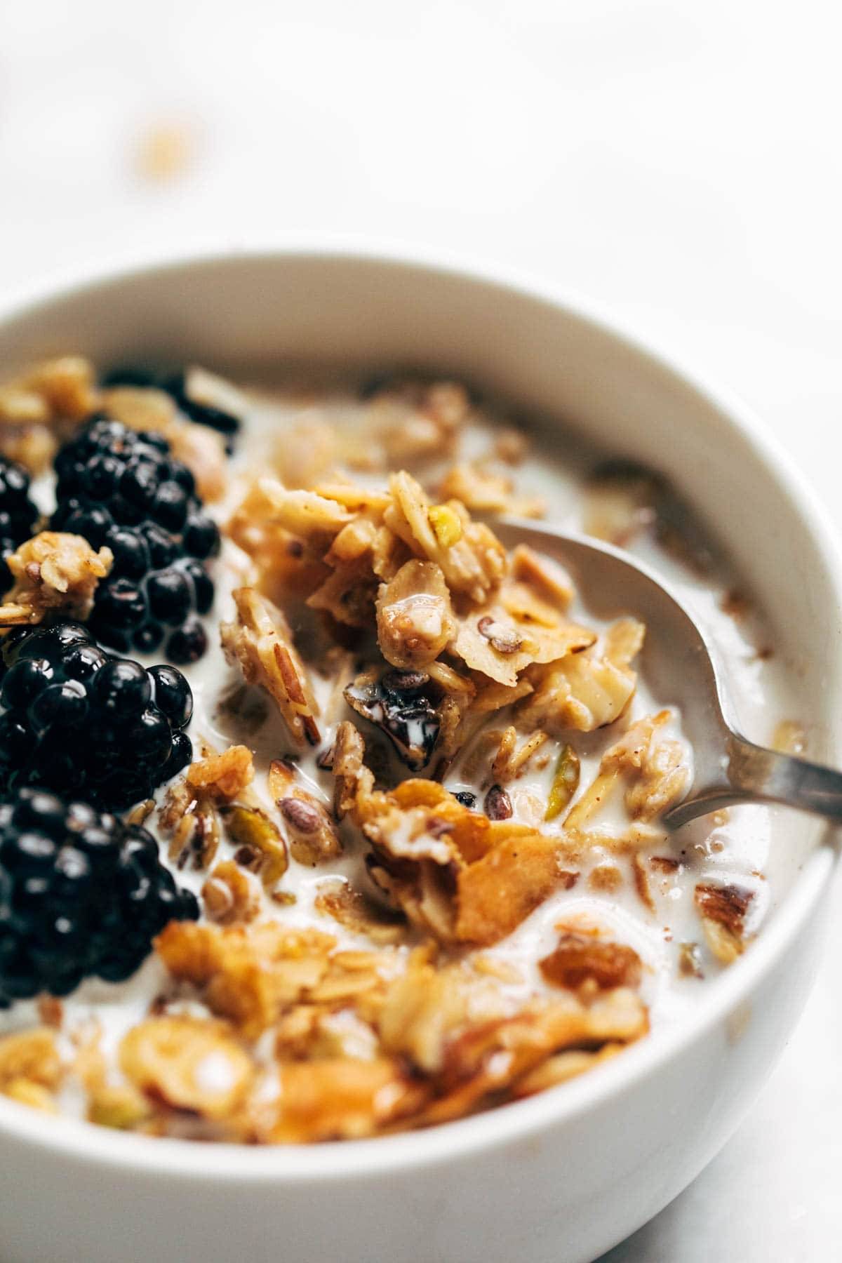Coconut oil granola in a bowl with milk and berries.
