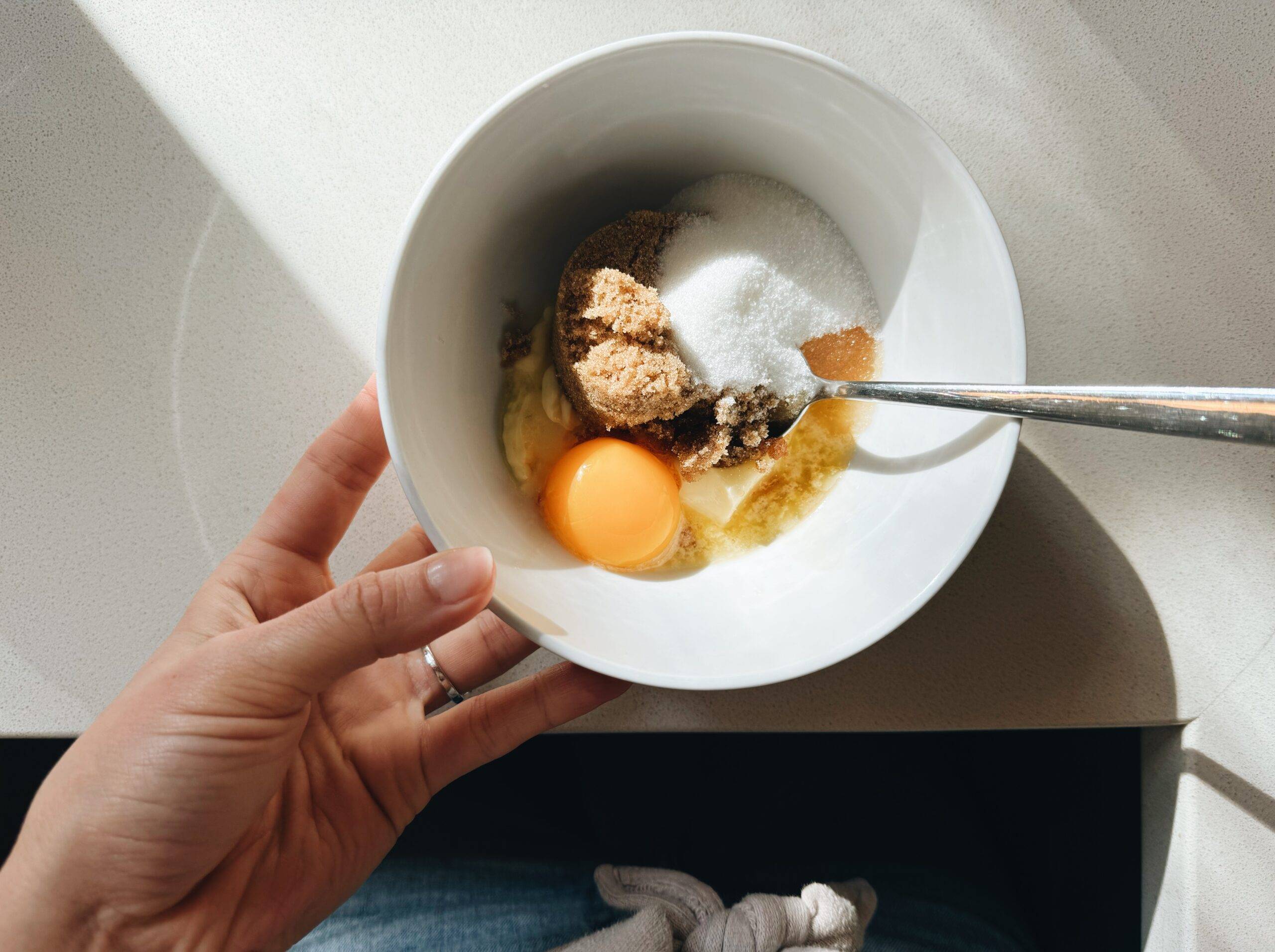 Butter, egg, and sugars mixed in a bowl.