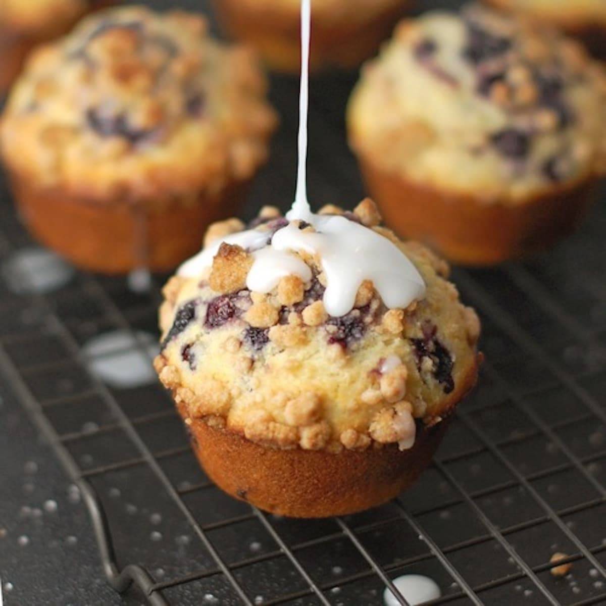 Cornmeal blueberry muffins topped with streusel and glaze.