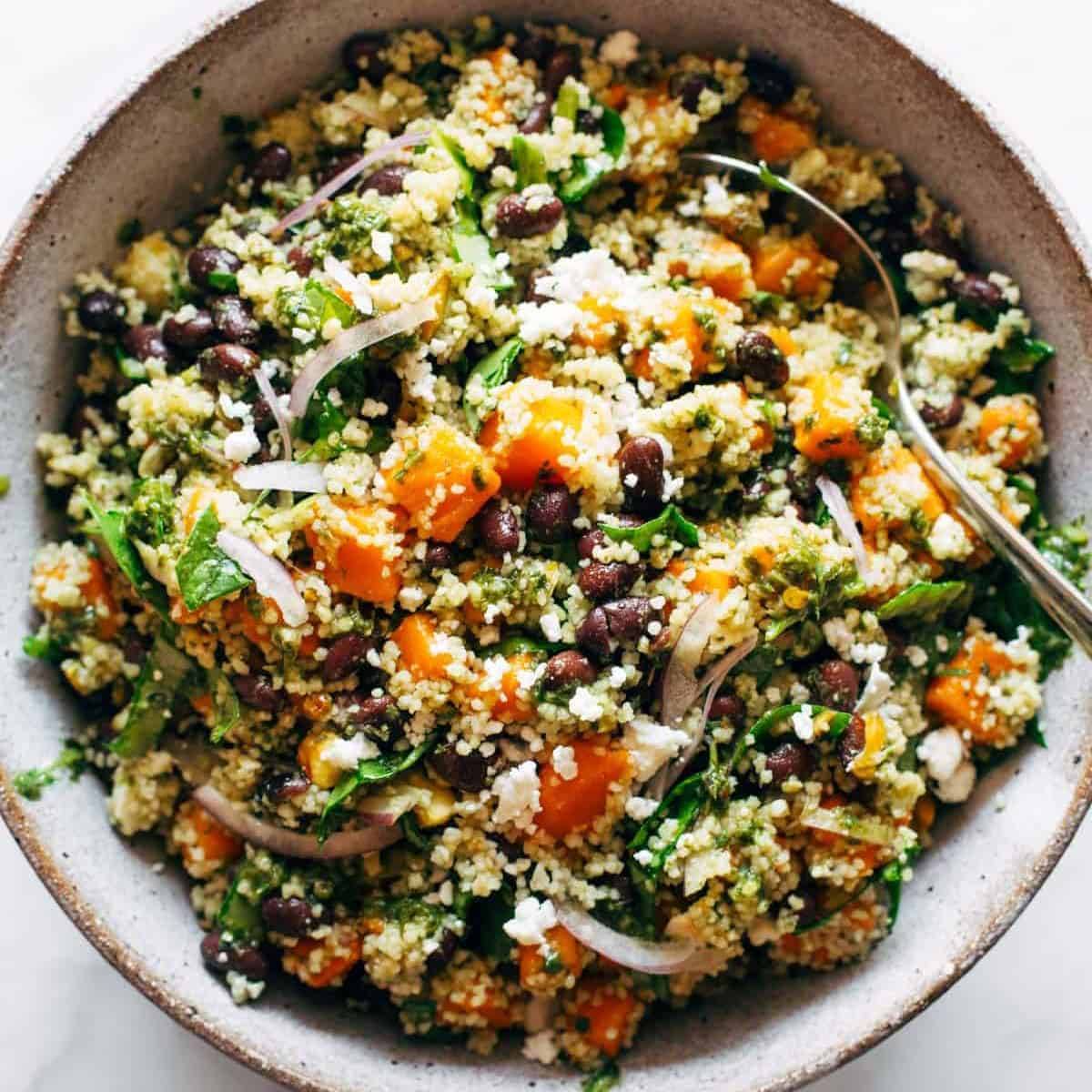 Couscous Salad with Lime Basil Vinaigrette in a bowl with a spoon.