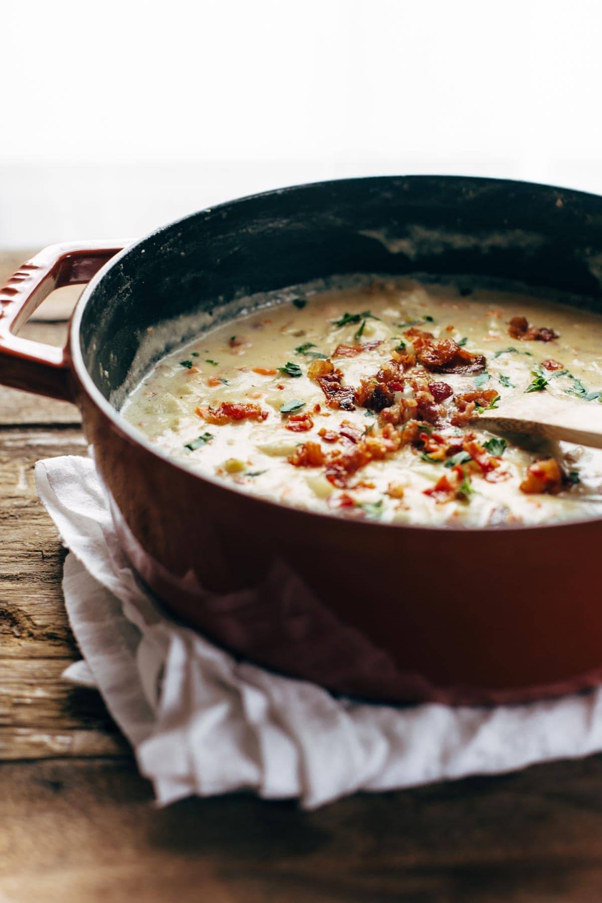 Creamy Potato Soup in a pot with a wooden spoon